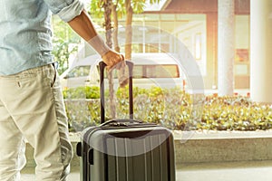 Asian man standing with suitcase luggage in the airport terminal travel concept.