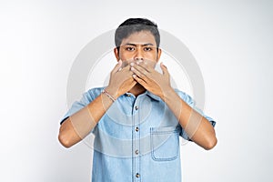 Asian man standing with two hands covering mouth