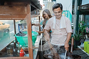 asian man stirring wok cooking oriental food