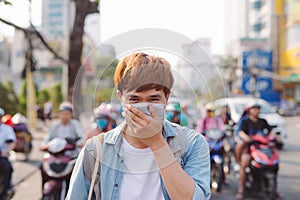 Asian man in the street wearing protective masks., Sick man with flu wearing mask and blowing nose into napkin as epidemic flu