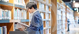 Asian man student reading book in library