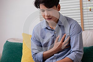 Asian man suffered a heart attack, resulting in chest pain and illness on the sofa