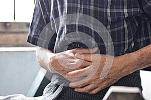 Asian man suffering from abdominal pain. It can be caused by stomach ache, enteritis, colitis, appendicitis, hepatitis,