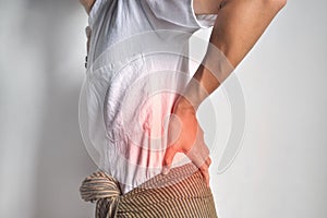 Asian man suffering from back and loin pain. It can be caused by renal stone