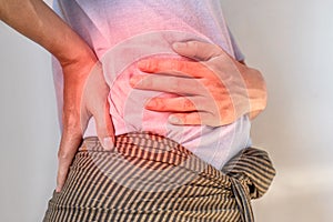 Asian man suffering from back and loin pain. It can be caused by renal stone