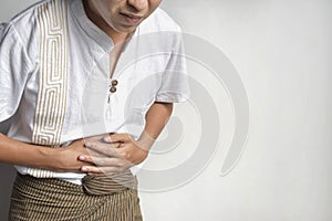 Asian man suffering from upper abdominal pain. It can be caused by stomach ache, enteritis, colitis, appendicitis, hepatitis,