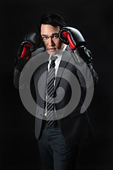 Asian man in suit and boxing gloves
