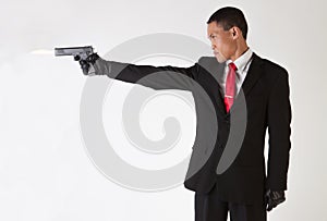 Asian Man in Suit and Tie Shooting Gun