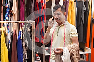 Asian man tailor phone call talking fashion