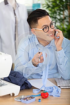 asian man tailor phone call talking fashion clothes
