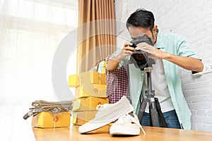 Asian man taking photo to shoes with digital camera for post to selling online on the internet