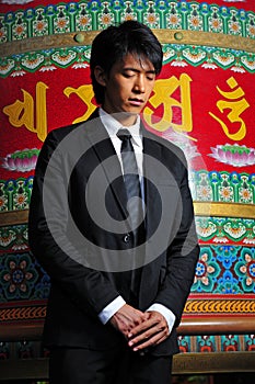 Asian Man In Temple with eyes shut photo