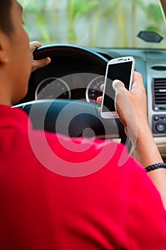 Asian man texting while driving