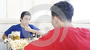 Asian man thinking about chess strategy