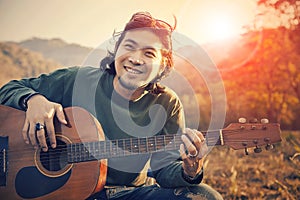 Asian man toothy smiling face with happiness playing guitar and photo