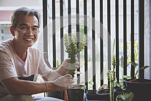 Asian man toothy smiling face holding  euphorbia planting in hand