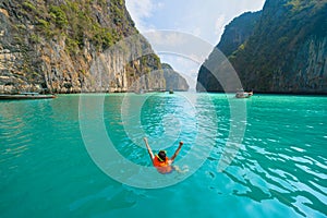 An Asian man, a tourist, diving, swimming or snorkeling in Krabi with blue turquoise seawater, Phuket island in summer season