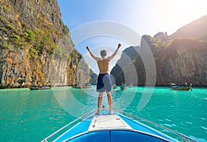 An Asian man, a tourist, standing on a boat to snorkeling or diving in Krabi with blue turquoise seawater, Phuket island in summer