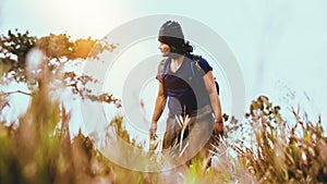 Asian man travel  nature. Travel relax.Backpack walk on the meadow in the forest. Thailand