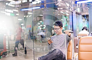 Asian man traveler using mobile phone in airport,Lifestyle using cell phone connection concept