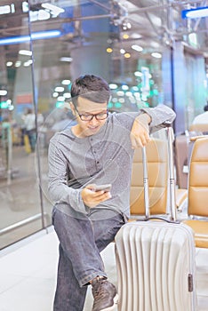 Asian man traveler using mobile phone in airport,Lifestyle using cell phone connection concept