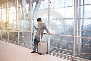 Asian man traveler using mobile phone in airport,Lifestyle using cell phone connection concept