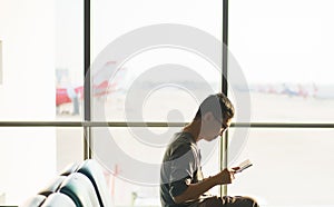 Asian man traveler using mobile phone internet and wifi in airport,Lifestyle using cell phone connection concept