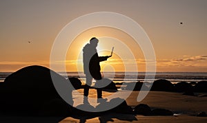 Asian man traveller visit at Moeraki Boulder, New Zealand. Frelancer remotely worker