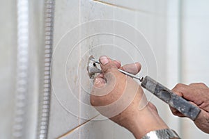 Asian man tries to fix and repair pipe / shower in the old restroom