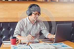 Asian man using laptop computer working on his new project idea in cafe working