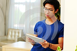 Asian man using tablet computer at home