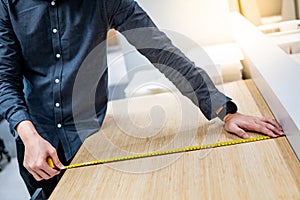 Asian man using tape measure on countertop