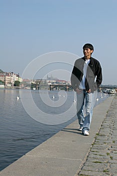 Asian Man Walking along the Embankment