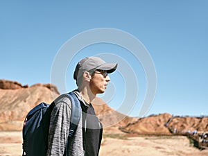 Asian man walking in national park with yardang landforms