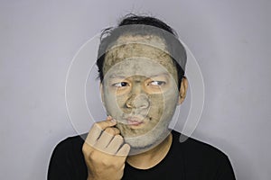 Asian Man was thinking and day dreaming when he use beauty face mask