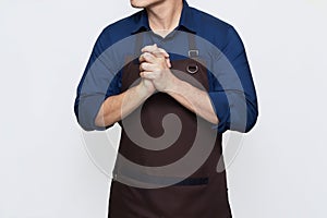 Asian Man wearing Apron with both hands clasped together, thinking gesture, isolated