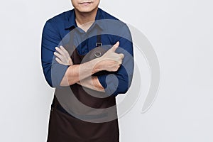 Asian Man wearing Apron folded hands and one hand giving a thumbs up, isolated