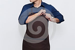 Asian Man wearing Apron tightening his apron string , ready to work, isolated