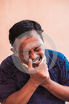 Asian man wearing a blue T-shirt and wearing a face mask