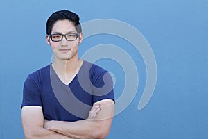 Asian man wearing glasses on a blue background - Stock image with copy space