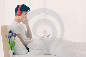 Asian man wearing red headphone, listening music