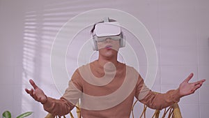 Asian man wearing virtual reality goggles in modern coworking studio. Smartphone using with VR headset