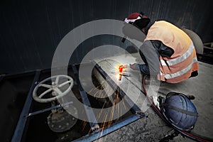 Asian man welding a metal grate