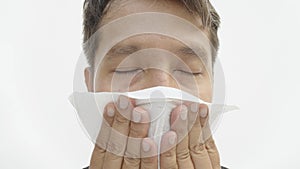 Asian man wiping his face with tissue paper close up.