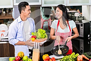 Asian man and woman cooking together