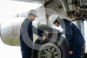 Asian man and woman engineer maintenance airplane team repairs, fixes, modernization and renovation in front airplane from  in