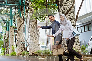 Asian man and woman in hijab to cross the street