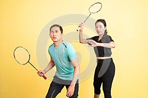 asian man and woman holding racket in ready for shuttle