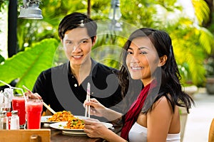 Asian man and woman in restaurant