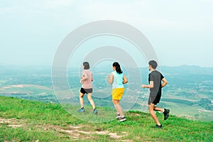 Asian man and woman trail runner running. On the high mountains, beautiful scenery. It`s a trail running practice. on a bright da